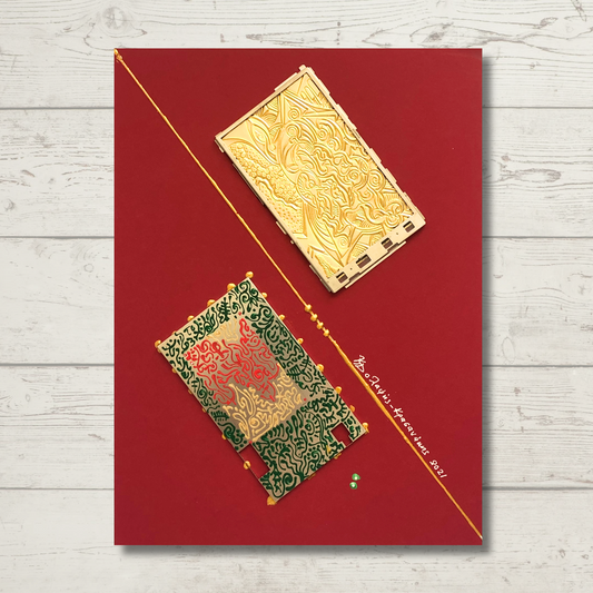 A bronze engraving of electronic device parts on a red cardboard base, featuring gold circuit-like details.